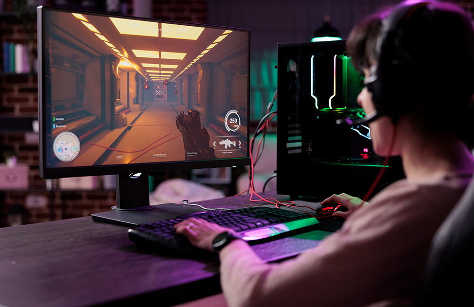 Bilgisayarda video oyunu oynayan kulaklık takan genç bir adam 