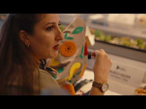 Elleri boynunda olan ve bir sınıfta ayakta duran bir kadın