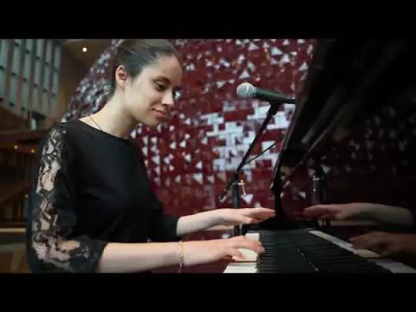 Bir kadın piyanonun önünde duruyor.